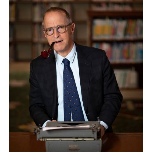 David Sedaris returns to Traverse City on October 30th, 2022. This is a photo of David Sedaris behind an old-time typewriter.