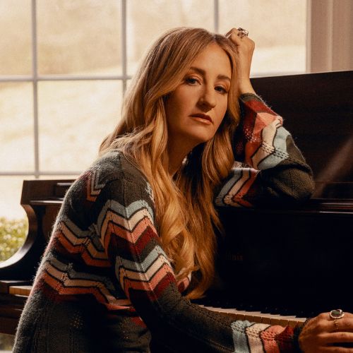 Margo Price sitting at a piano
